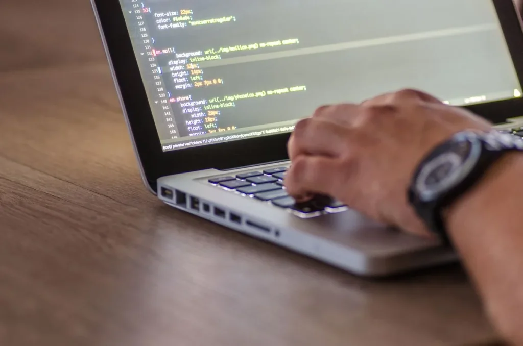 Programátor píšící kód na notebooku